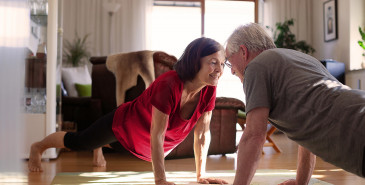 Elderly couple exercising on living room floor