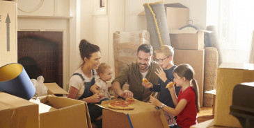 Family celebrating moving into new house eating pizza