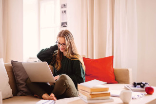 Young women using laptop on couch 