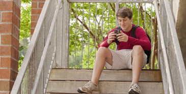 Student on phone sitting on university steps