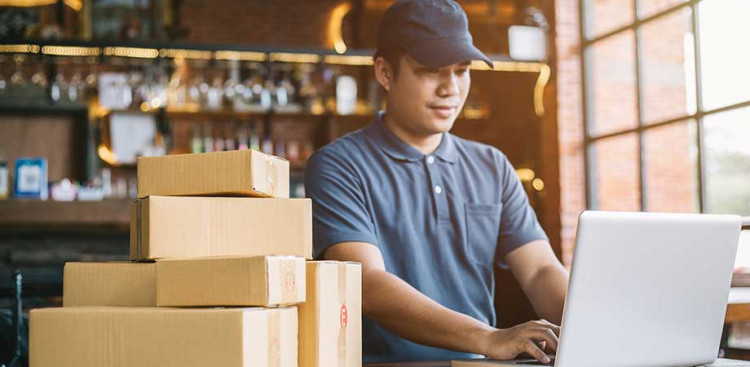 A man working on a laptop in a warehouse