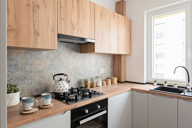 modern kitchen with wooden cupboards and tiled splashback